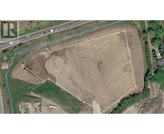 A satellite image shows a large open field with a road running through it.