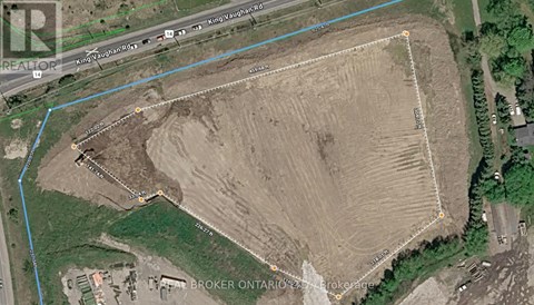 A satellite image shows a large open field with a road running through it.