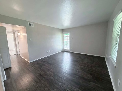 Room with wooden flooring and white walls.