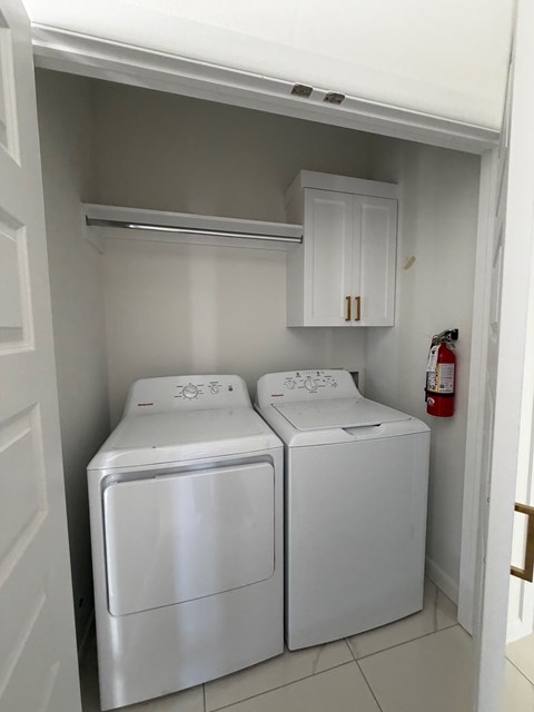 A white washing machine and dryer in a small laundry room.