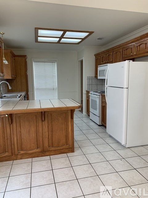 A kitchen with wooden cabinets and white appliances.