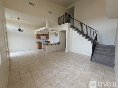 A spacious living room with a staircase leading to the upper floor.