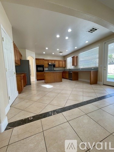 A spacious kitchen with wooden cabinets and a black countertop.