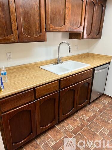 A kitchen with wooden cabinets and a white sink.