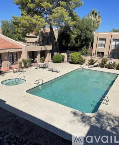 A pool surrounded by chairs and trees.