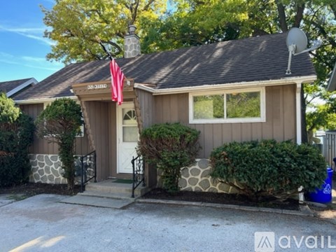 A house with a flag on the front porch is for sale.