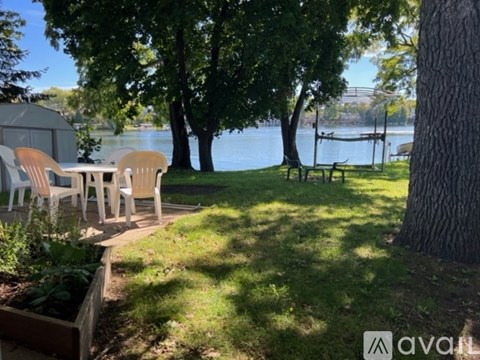 A patio with chairs and a table overlooking a lake.