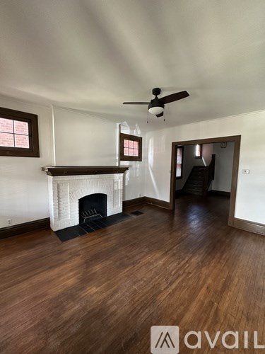 A room with a fireplace and a ceiling fan.