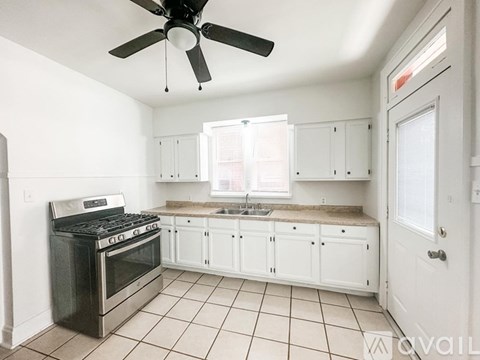 A kitchen with white cabinets and a black stove top oven.