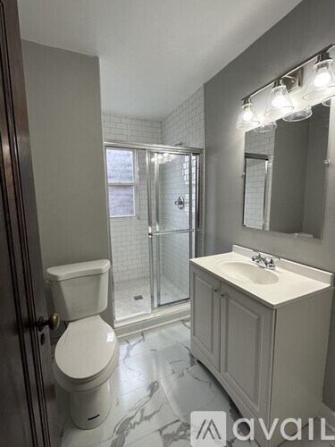 A bathroom with a toilet, sink, and mirror.