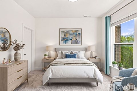 A bedroom with a large bed, a nightstand with a lamp, and a painting on the wall.