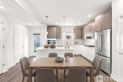 A modern kitchen with a dining table and chairs.