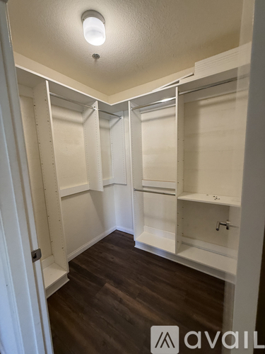 A kitchen with white cabinets and a wood floor.