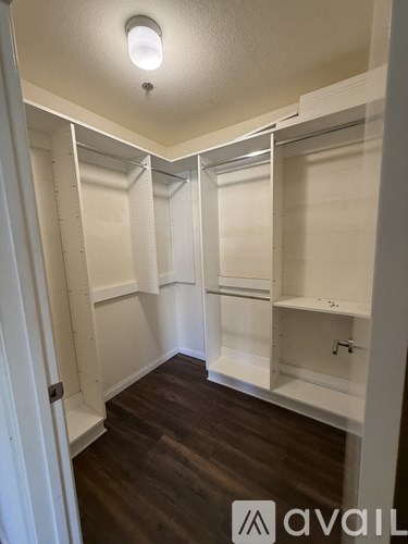 A kitchen with white cabinets and a wood floor.