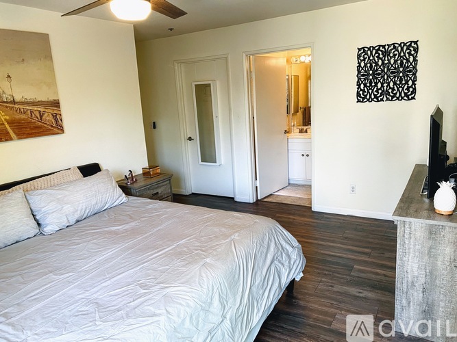 A bedroom with a large bed and a painting on the wall.
