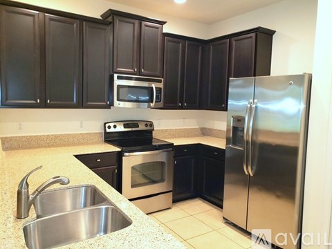 A kitchen with black cabinets and stainless steel appliances.