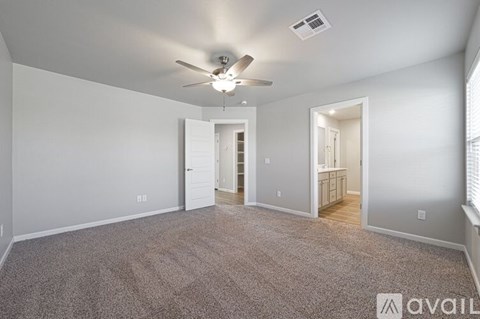 A spacious room with a ceiling fan and carpeted floor.
