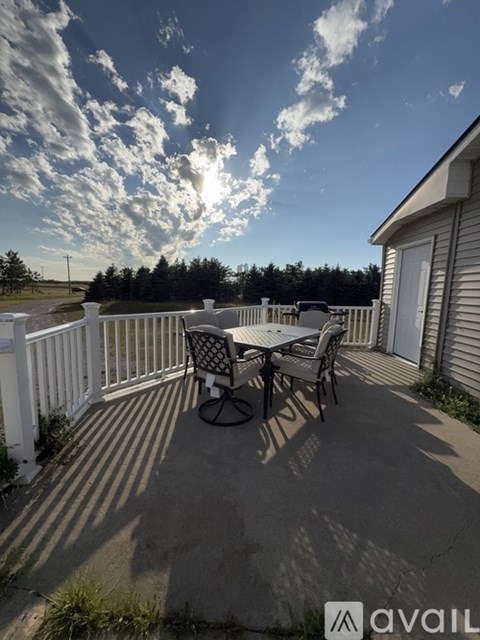 A patio with a table and chairs is set up on a sunny day.