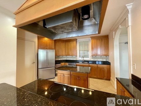 A kitchen with wooden cabinets and a black countertop.
