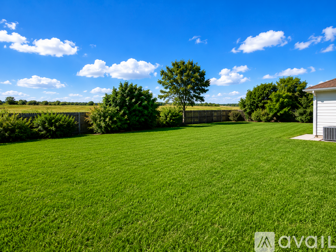 A large, well-maintained lawn with a white shed and a few trees in the distance under a blue sky with scattered clouds.
