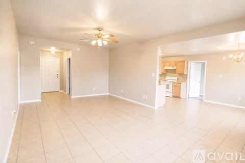 A spacious room with a ceiling fan and lighting fixture.