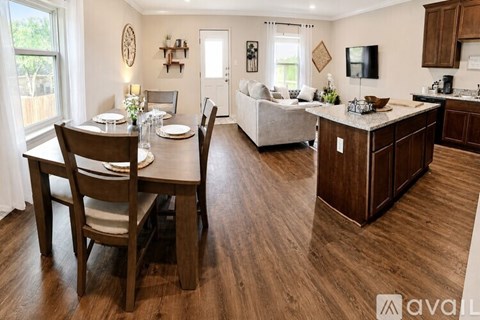 A modern kitchen and dining area with wooden floors and furniture.