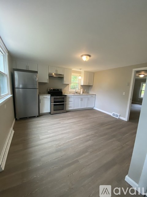 A kitchen with a refrigerator, stove, and cabinets.
