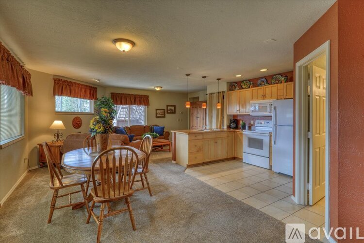 A living room with a dining table and chairs.