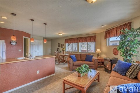 A living room with a brown couch and a wooden coffee table.