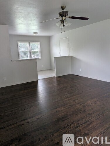A room with wooden floors and a ceiling fan.