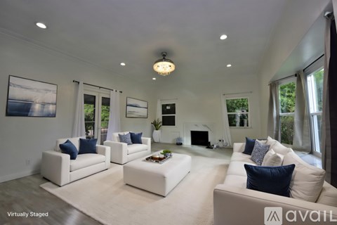 A living room with white furniture and a chandelier.