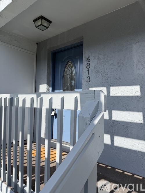 A white house with a blue door and a number 48013 on the wall.