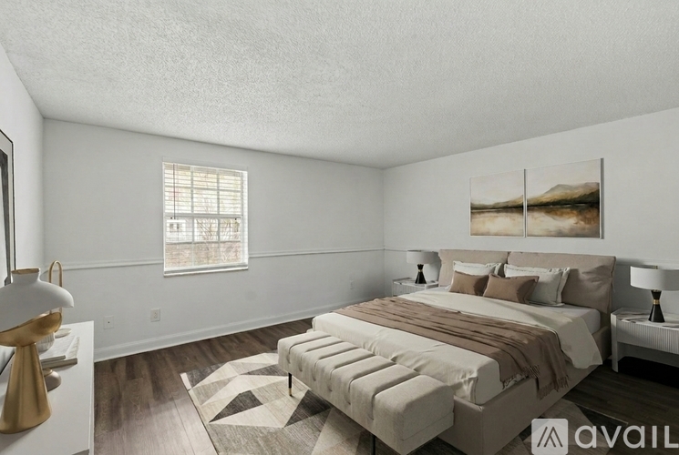 A bedroom with a large bed and a painting on the wall.
