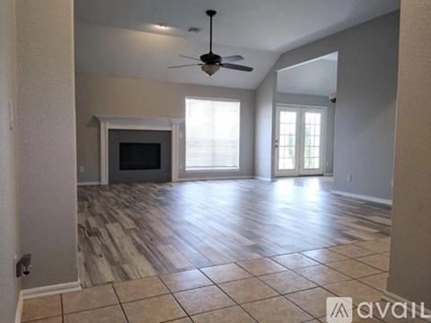 A living room with a fireplace and a ceiling fan.