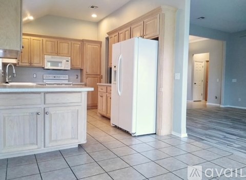 A kitchen with wooden cabinets and a white refrigerator.