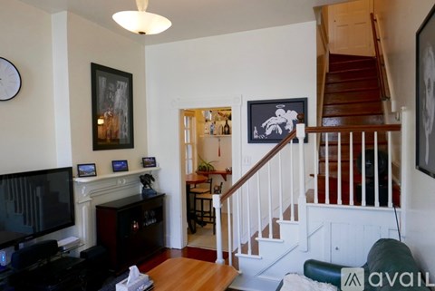A living room with a staircase and a fireplace.