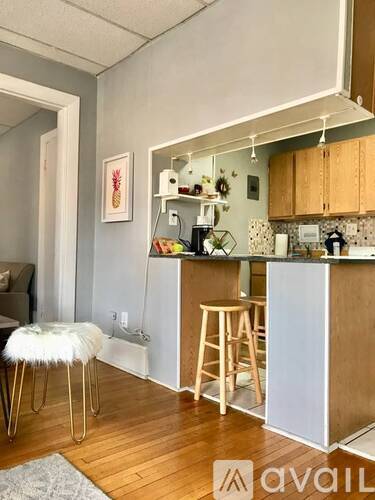 A kitchen with a white stool and a white chair.
