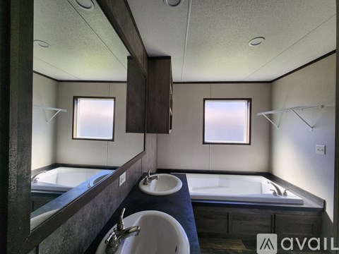 A bathroom with a tub, sink, and mirror.