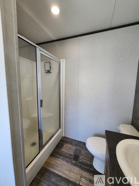 A bathroom with a toilet, sink, and shower.