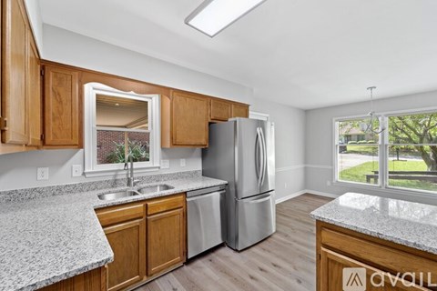 A kitchen with wooden cabinets and a granite countertop.
