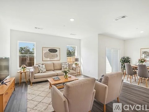 A living room with a couch, chairs, and a coffee table.