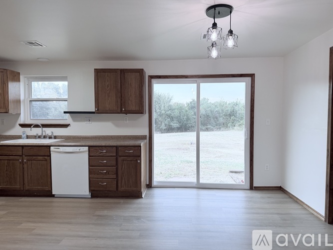 A kitchen with brown cabinets and a white dishwasher.
