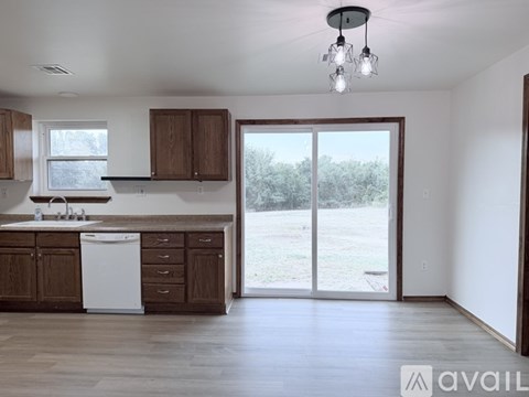 A kitchen with brown cabinets and a white dishwasher.