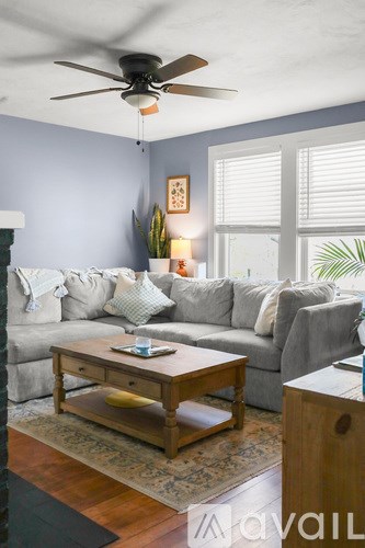 A living room with a grey couch and a wooden coffee table.