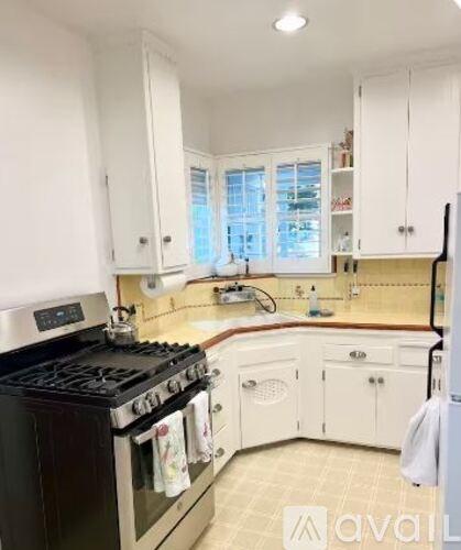 A kitchen with white cabinets and a black stove top.