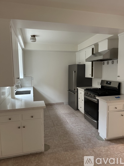 A kitchen with white cabinets and appliances.