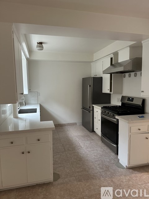 A kitchen with white cabinets and appliances.