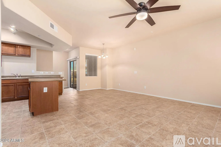 A spacious room with a ceiling fan and tiled flooring.