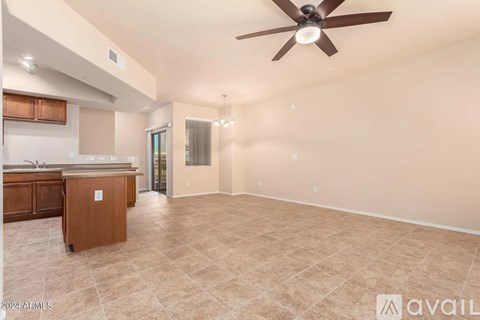 A spacious room with a ceiling fan and tiled flooring.