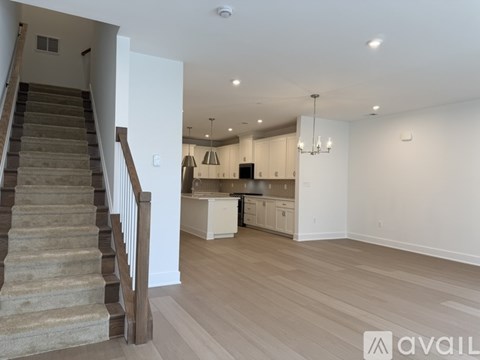 A spacious living room with a staircase leading to the upper floor.